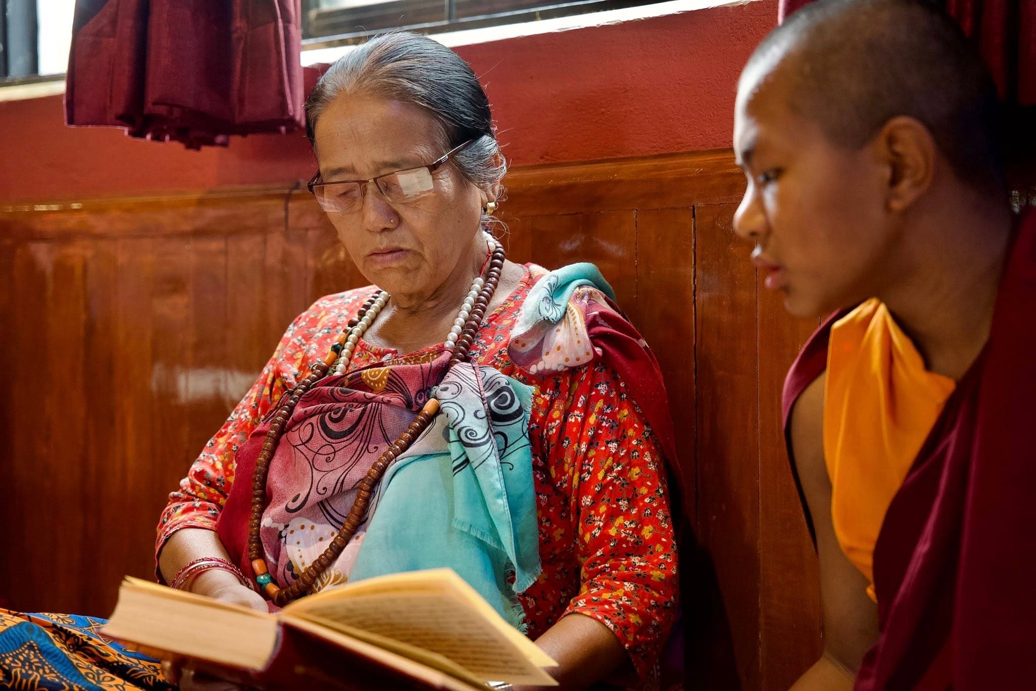 Guru Aama Along With A Monk Reading Books